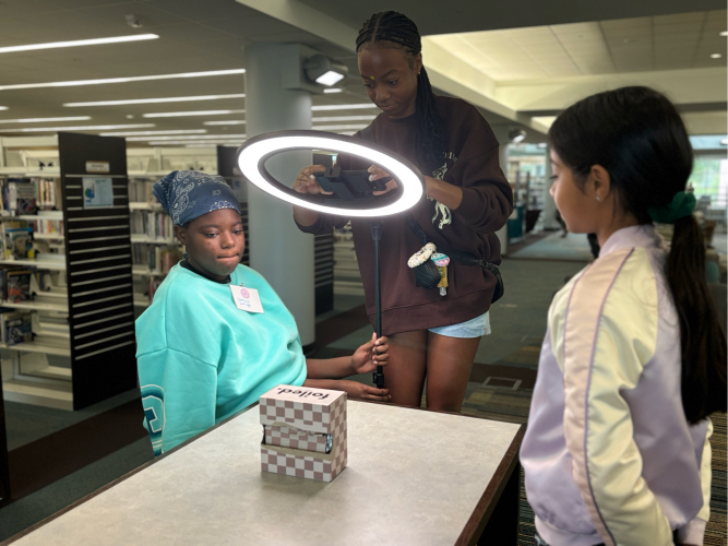 Girls Code Savannah Summer camp students using a ring light to enhance product photography for future Foiled Pretty product marketing efforts
